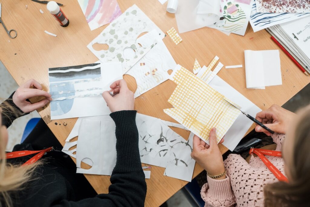 Students cutting up designs on papaer