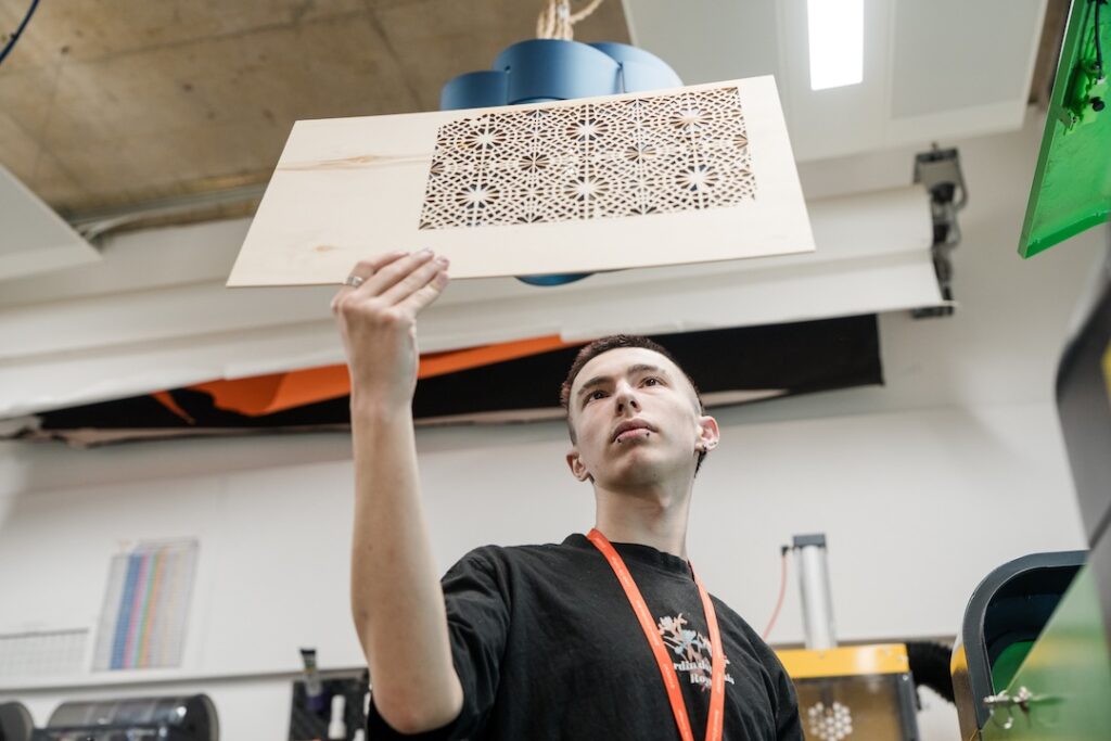 Student burning mosaic patterns onto wood
