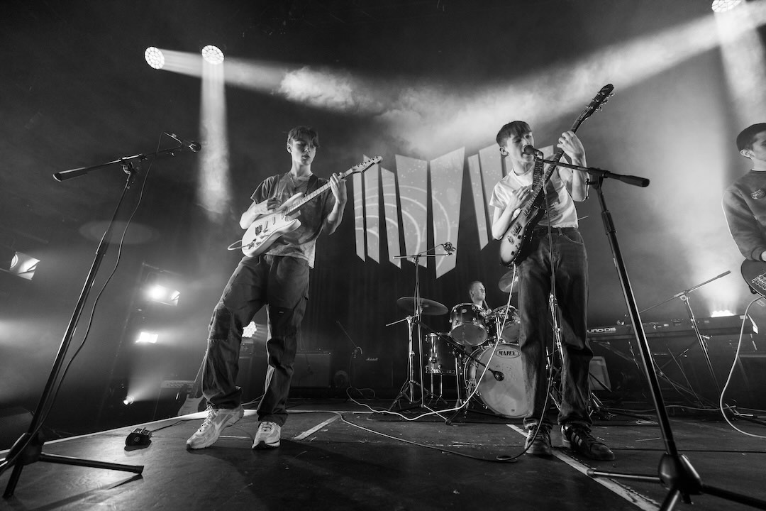 Black and white shot of a full band playing on stage