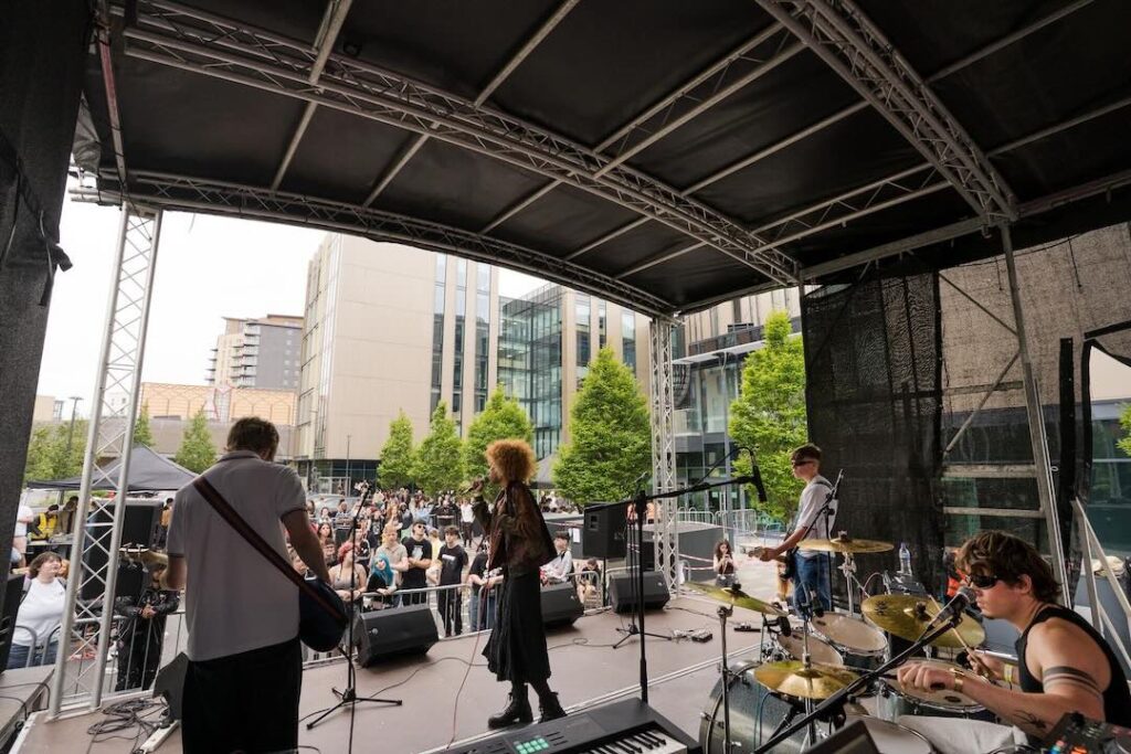A band of students performing outside of quarry hill on the outdoor stage