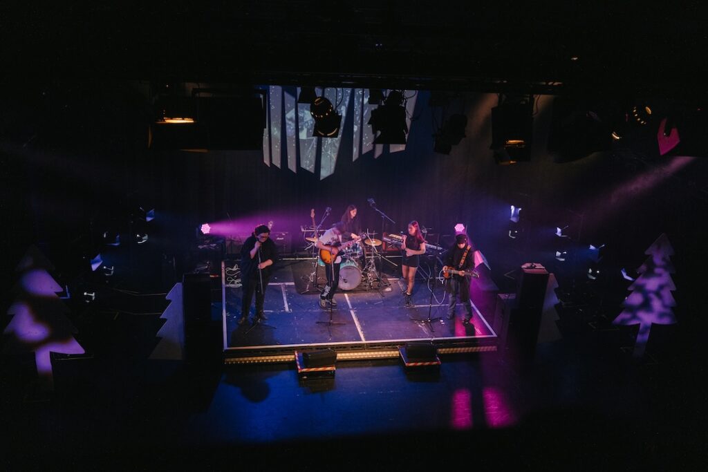 A band of students performing live with a light show