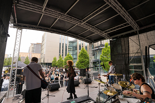 A music band performing on stage at Quarry Hill in front of an audience